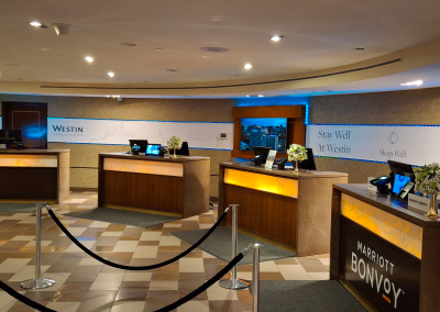 Front desk of The Westin Ottawa with elegant white and green floral arrangements on display, providing a welcoming and luxurious atmosphere.