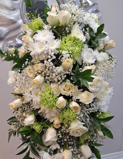 Tall standing sympathy spray with white roses, chrysanthemums, and greenery
