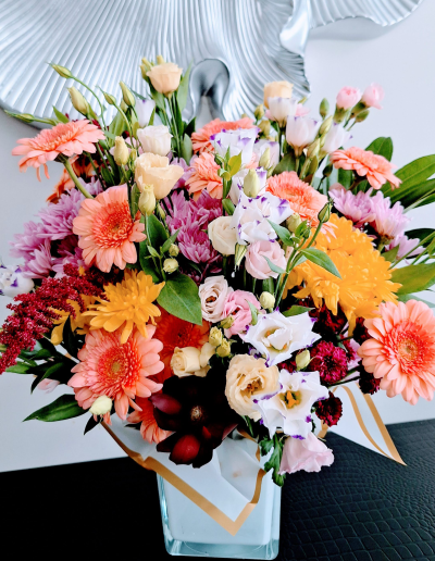 Colourful mixed flower arrangement in a clear glass vase.