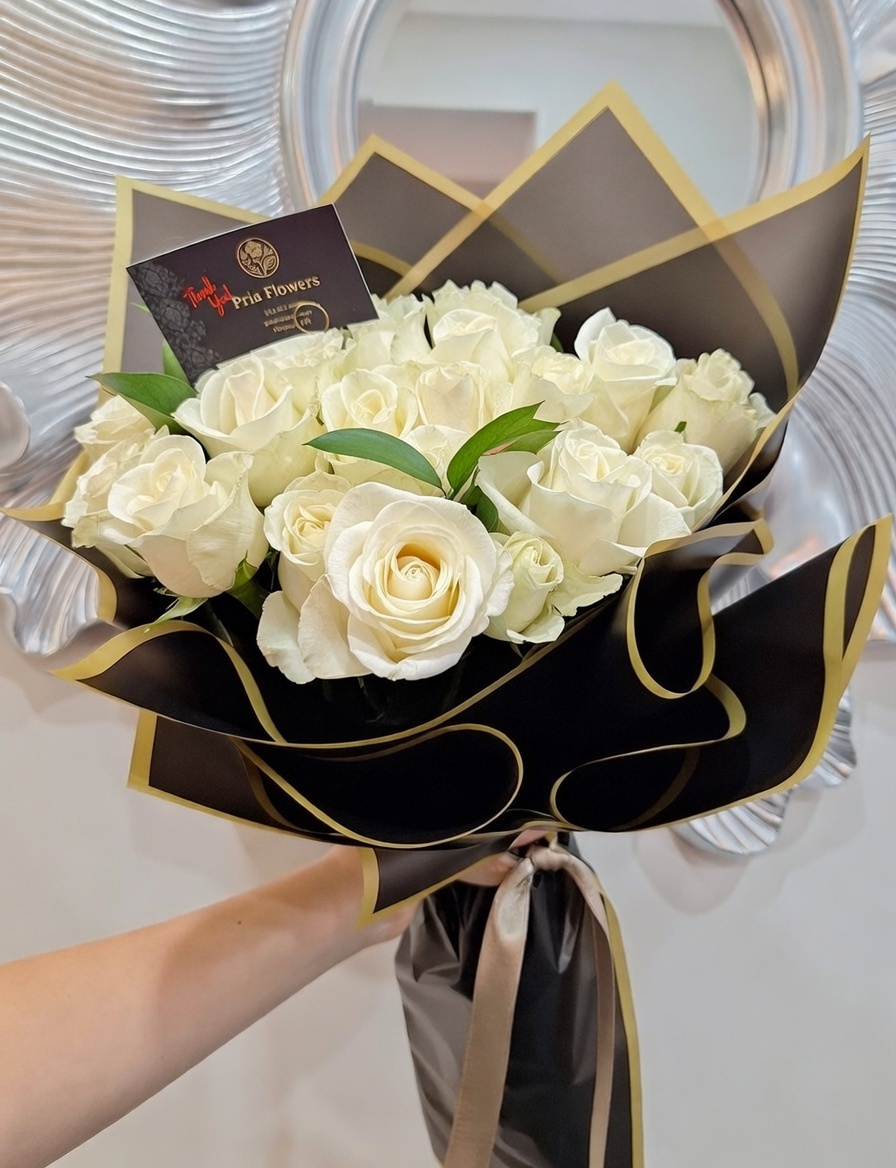 Handheld red rose bouquet wrapped in black and gold paper.